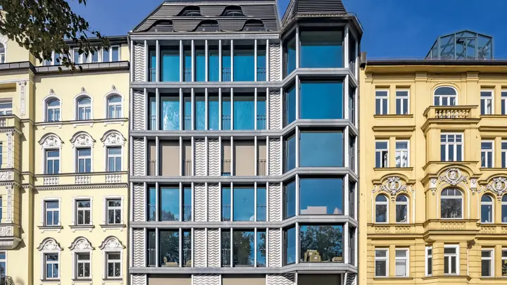 Stadthaus mit moderner Glasfassade zwischen Altbauten in München