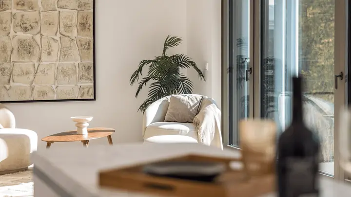 Wohnzimmer mit Wandbild, Pflanze und Blick auf die Glasfront