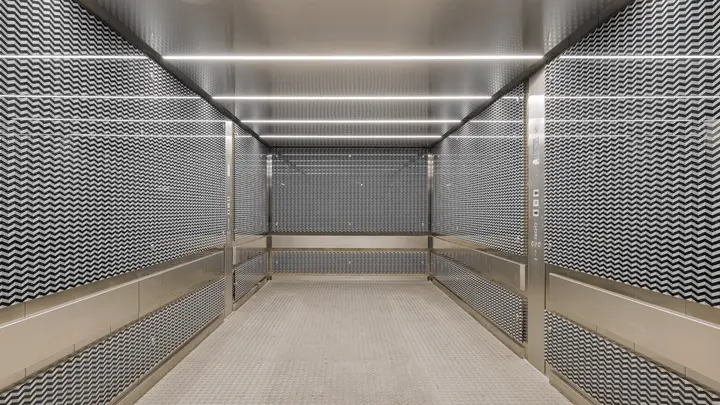 Gang mit perforierten Metallwänden und Lichtband in einem Architektenobjekt