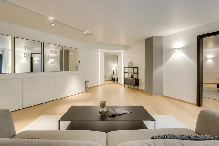 Langer Wohnraum mit Sofa, Couchtisch und Sideboard