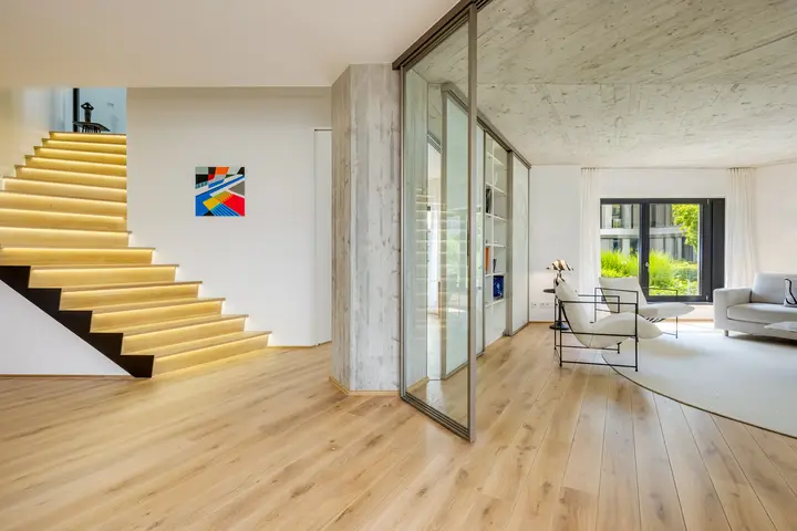 Wohnraum mit beleuchteter Treppe und Glaswänden in einem Architektenhaus