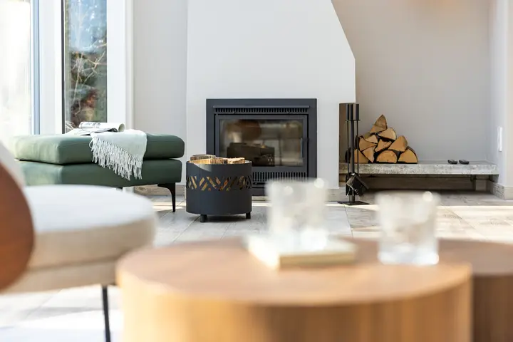 Wohnzimmer mit Kamin und grünem Sofa