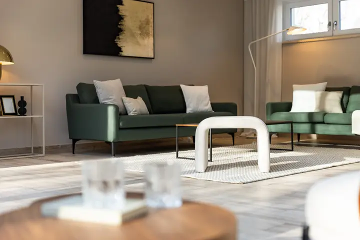 Wohnzimmer mit grüner Sofagruppe und Couchtisch