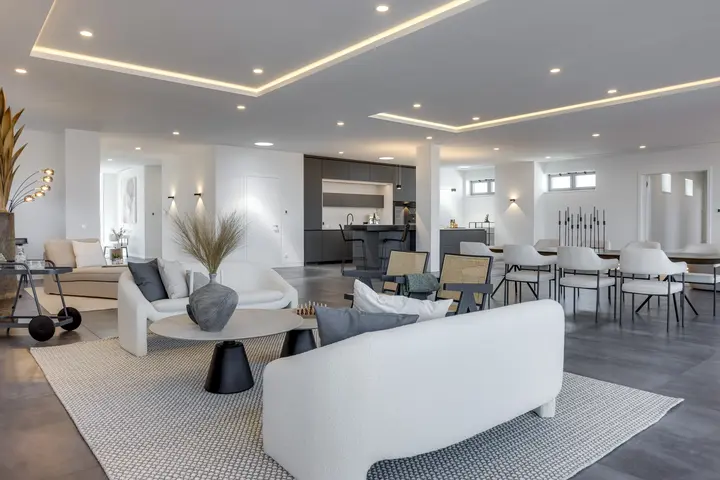Wohnbereich mit weißem Sofa und langer Esstafel