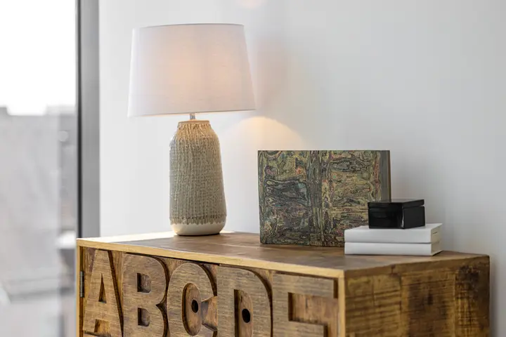 Kommode aus Holz mit Tischleuchte und Dekoration