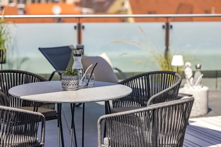 Essplatz mit Geflechtstühlen auf der Dachterrasse