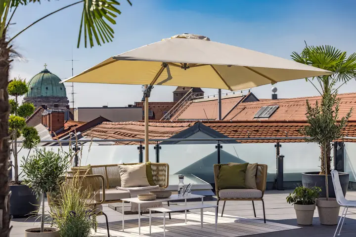 Dachterrasse mit Sonnenschirm, Palmen und Blick auf die Kuppel