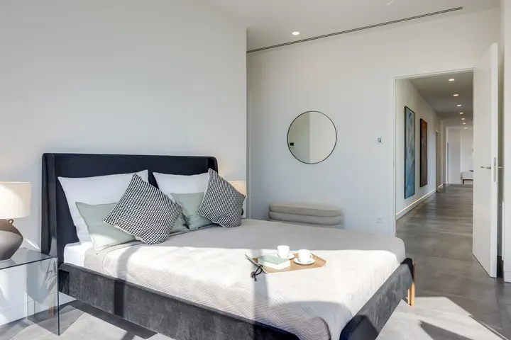 Schlafzimmer mit Polsterbett und Flur im Hintergrund