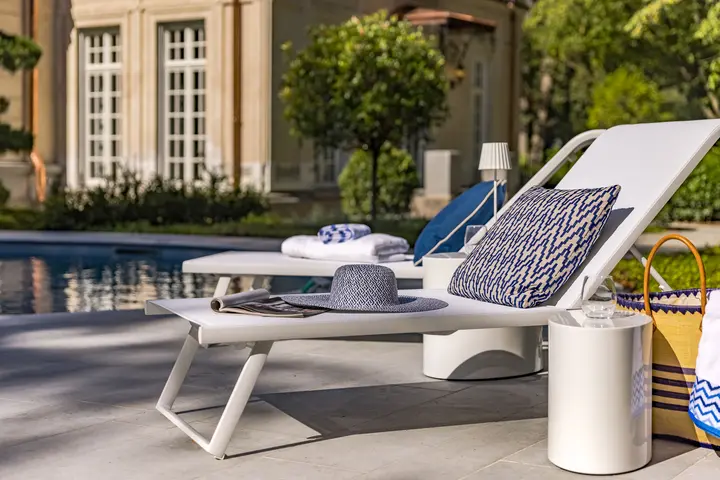 Sonnenliegen am Pool mit Handtüchern und Kissen