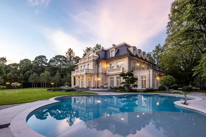 Villa mit beleuchtetem Pool in der Abenddämmerung