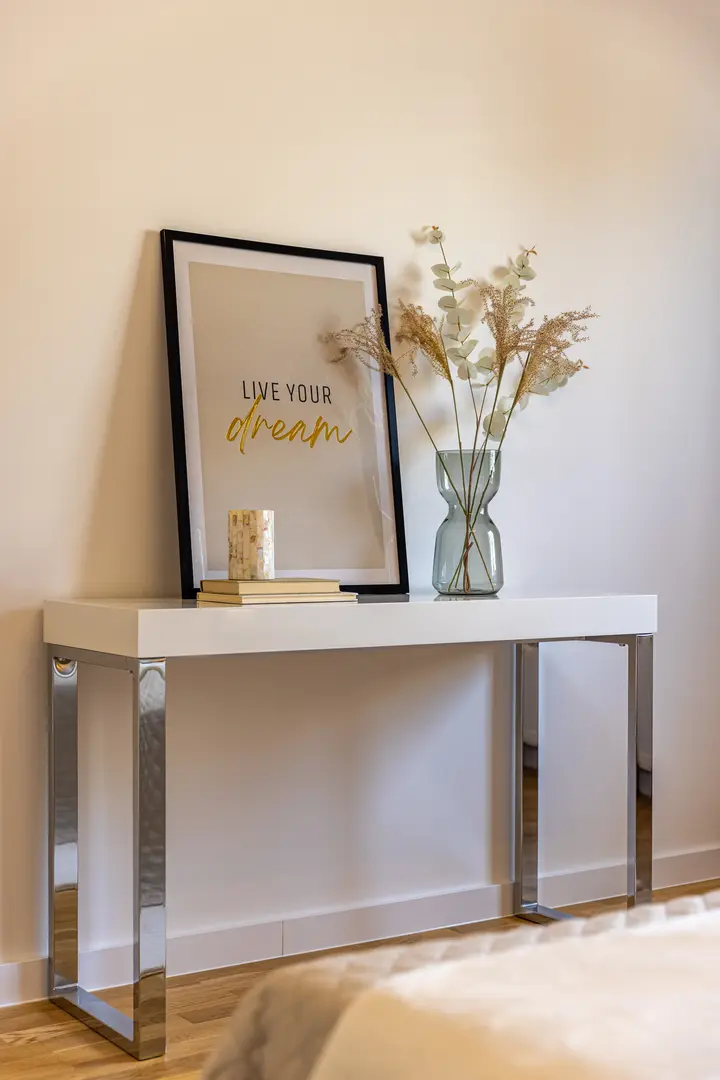 Konsole mit Bild und Trockenblumen im Flur