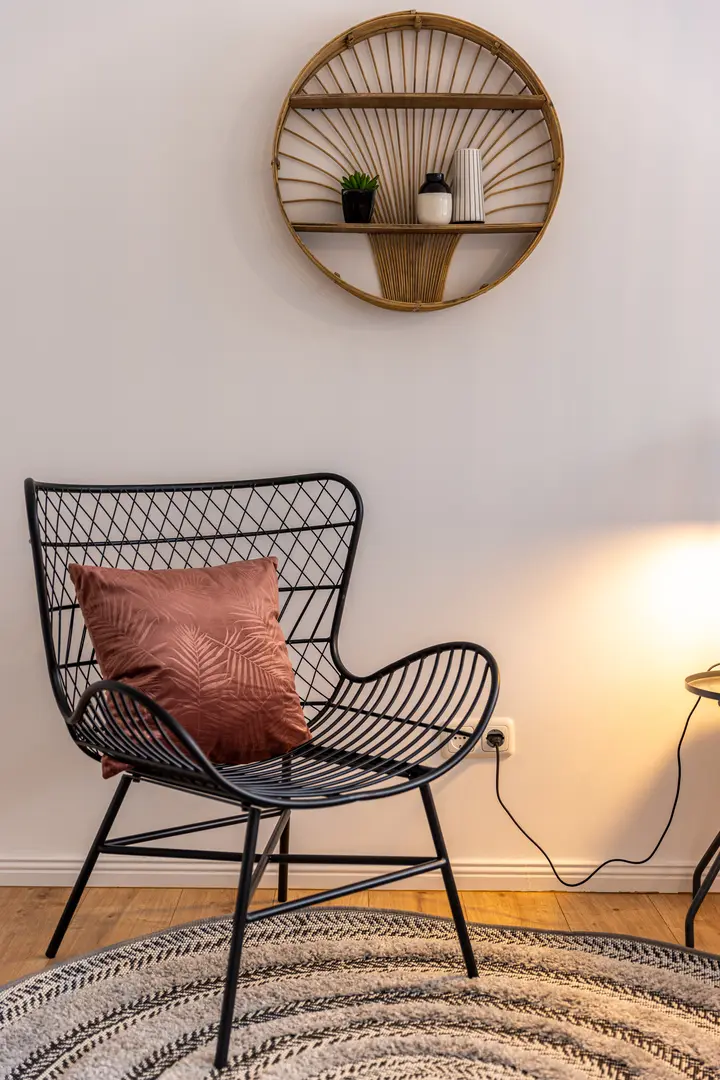Rattansessel mit Kissen und Wandspiegel