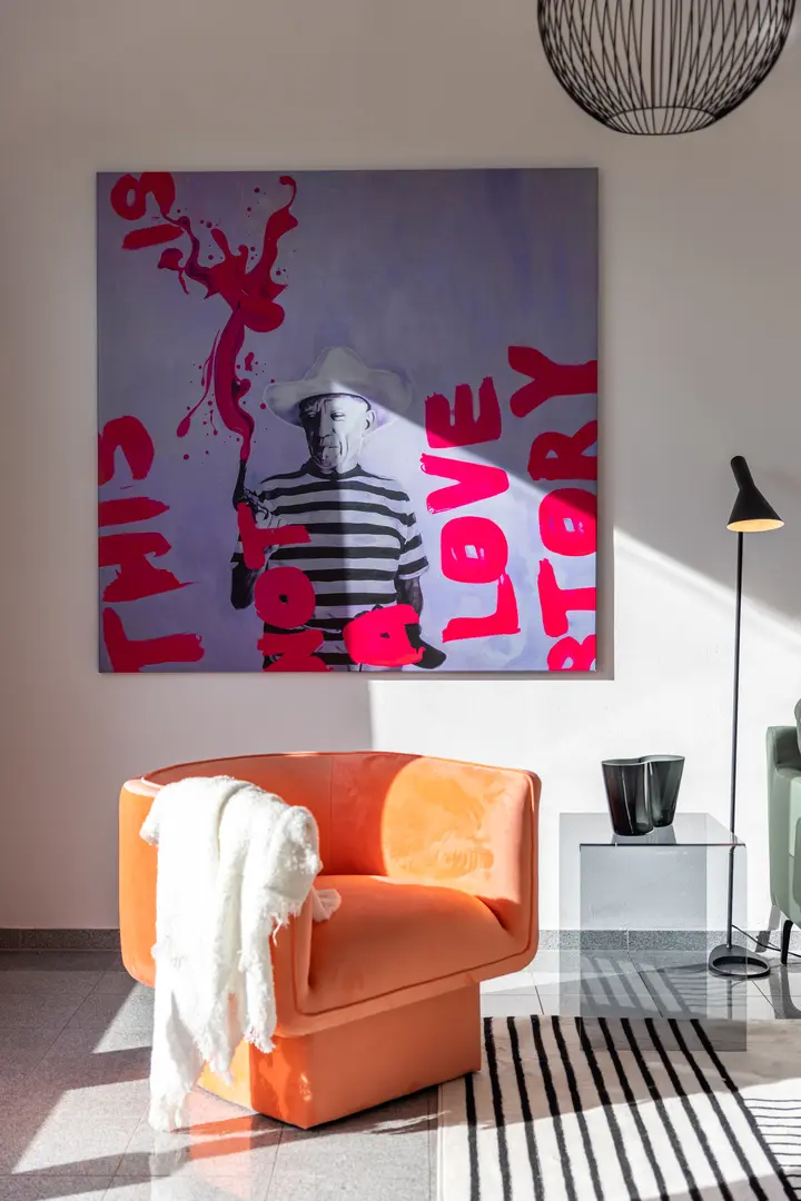 Orangefarbener Sessel vor einem großen Pop-Art-Bild