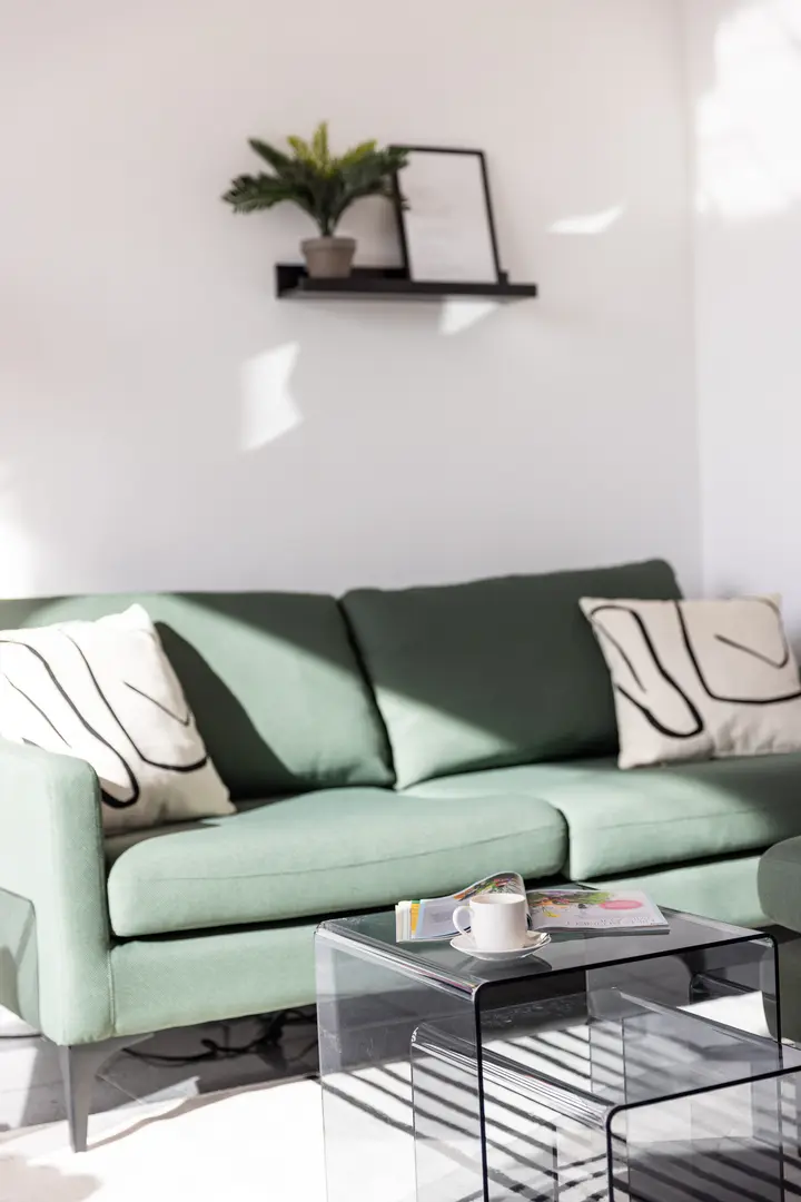Grünes Sofa mit Kissen und Couchtisch
