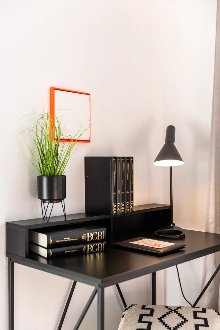 Schreibtisch mit Leuchte und Büchern