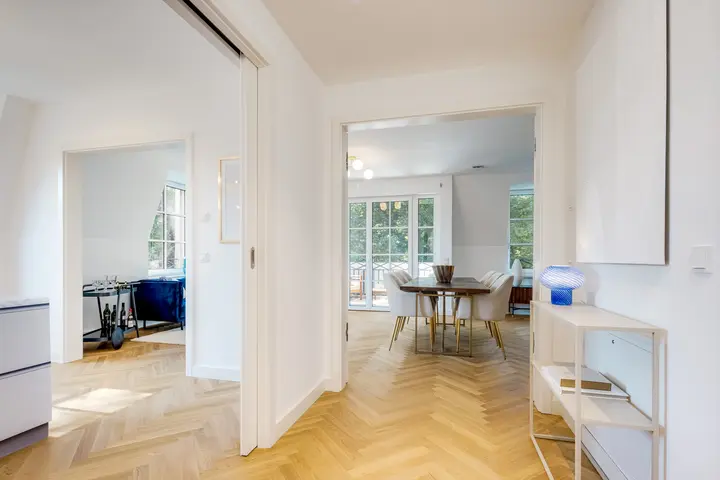 Blick durch eine Neubauwohnung mit Fischgrätparkett zum Essplatz