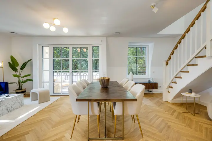 Essbereich mit langer Tafel und Treppe in einer Musterwohnung im Neubau
