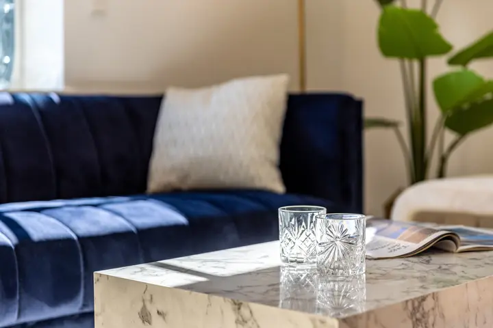 Detail mit blauem Samtsofa und Marmortisch