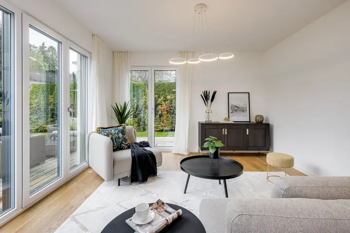 Wohnzimmer mit Sofa, rundem Couchtisch und Sideboard in einem Musterhaus