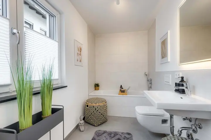 Bad mit Wanne, Waschtisch und dekorativen Gräsern
