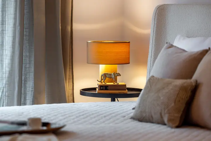 Bett mit Tischleuchte in warmem Licht