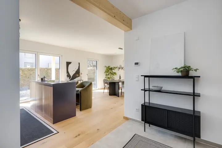 Offene Küche mit Insel und Regal in einem Musterhaus