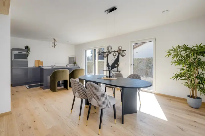 Essbereich mit ovalem Tisch und Polsterstühlen in einer Neubauwohnung