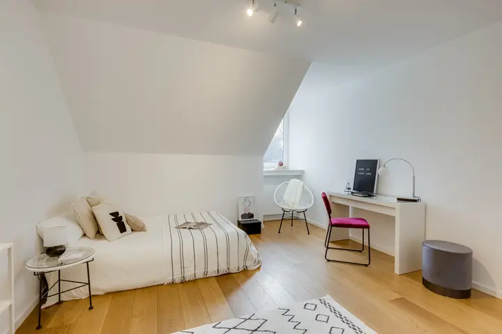 Gästezimmer unter der Dachschräge mit Bett und Schreibtisch