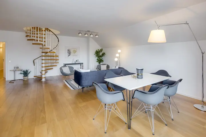 Essplatz mit Designerstühlen unter der Dachschräge