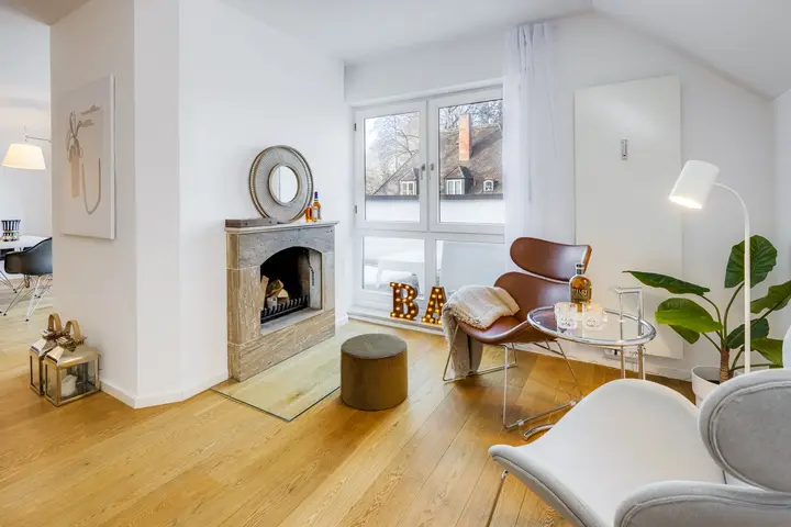 Wohnzimmer mit Kamin, Sessel und Pflanze, Home Staging im Dachgeschoss