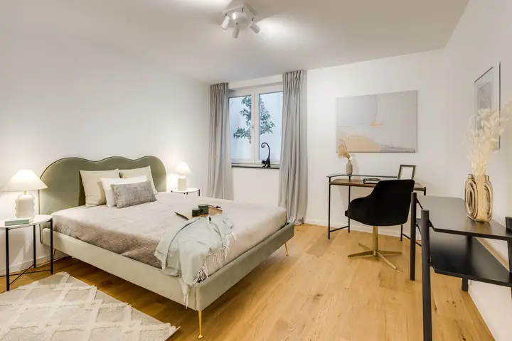 Schlafzimmer mit Bett und Schreibtisch in einem schmalen Raum