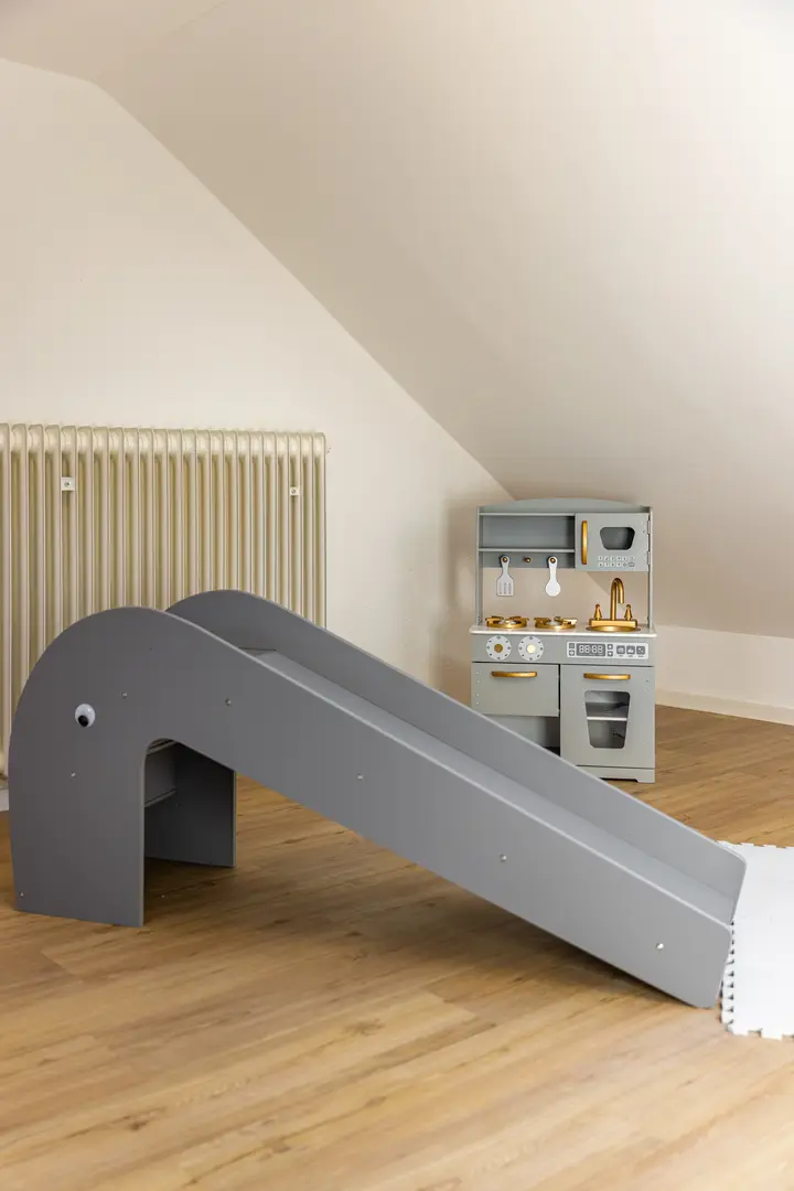 Kinderzimmer mit Rutsche unter der Dachschräge