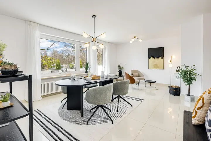Essbereich mit Rundtisch und Wohnzimmer mit Ausblick