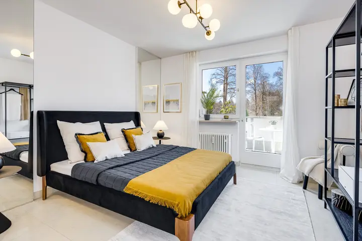 Schlafzimmer mit dunklem Bett und gelber Decke