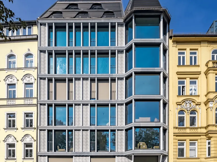 Stadthaus mit moderner Glasfassade zwischen Altbauten in München
