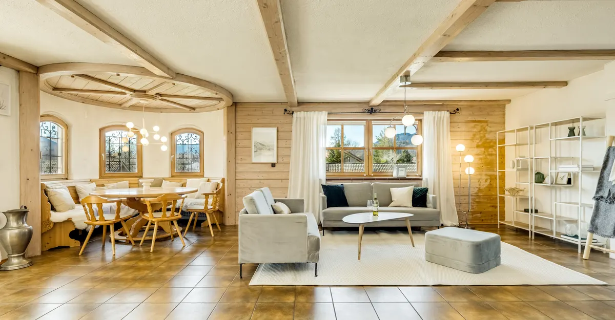 Wohnbereich mit Holzbalken nach dem Home Staging mit Sofa, Essplatz und Regal