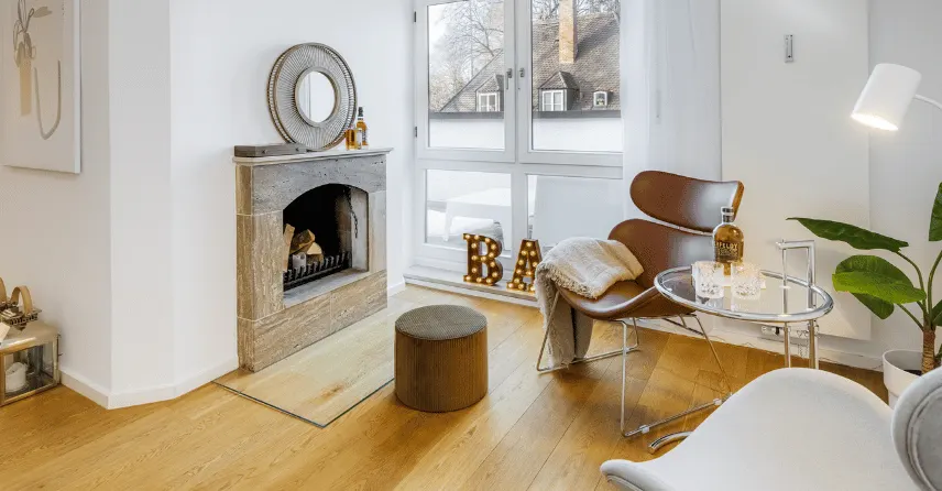 Wohnzimmer mit Kamin nach dem Home Staging mit Lounge-Sessel, Stehleuchte und Pflanzen