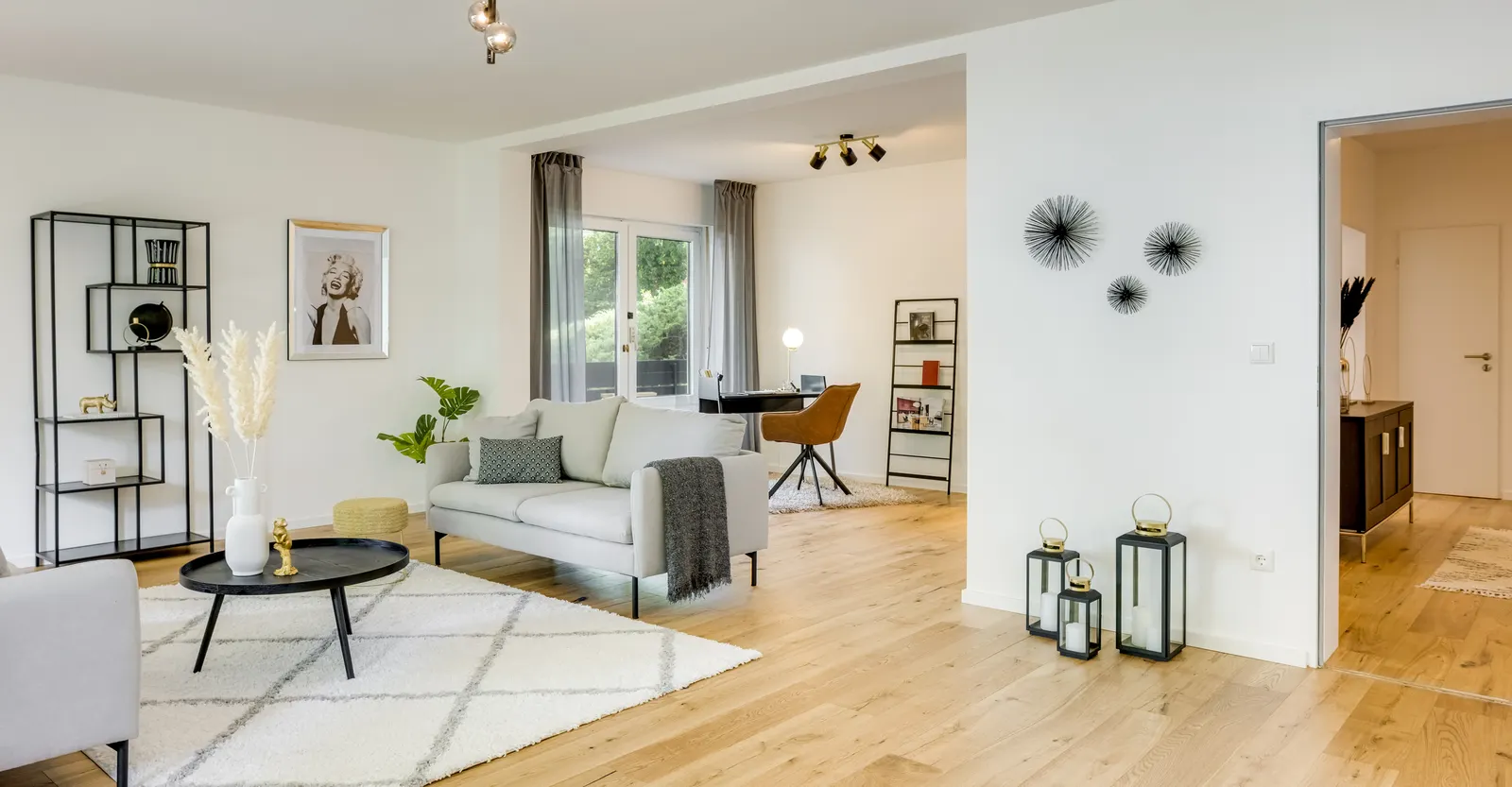 Wohnbereich mit Sofa, Regal und Arbeitsplatz nach dem Home Staging