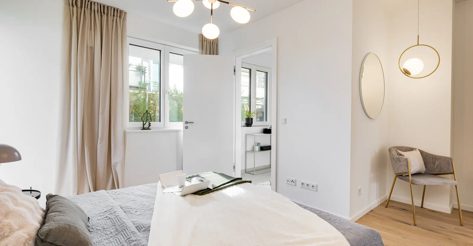 Schlafzimmer mit Bett, Sessel und Leuchten nach dem Home Staging