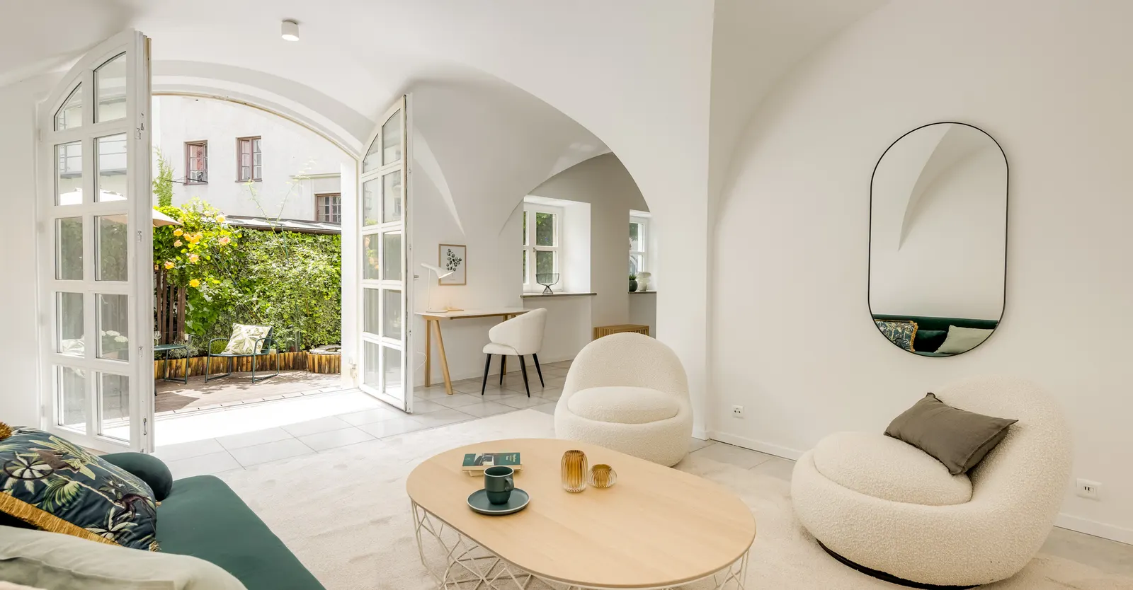 Gewölbter Wohnbereich mit Sofa und Sesseln nach dem Home Staging