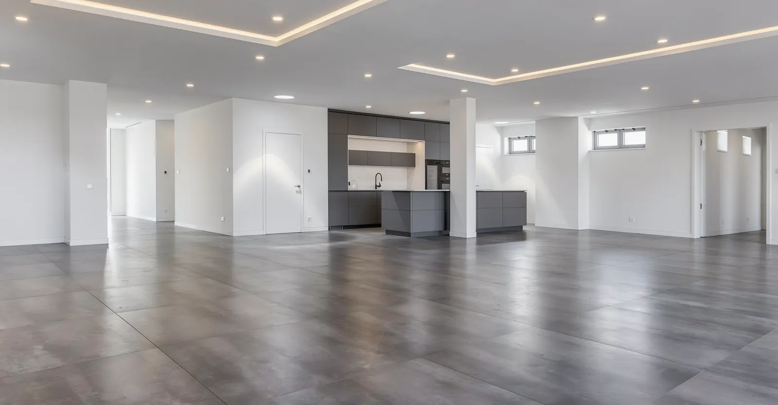 Leerer offener Wohnbereich mit Lichtvoute und Küche vor dem Home Staging