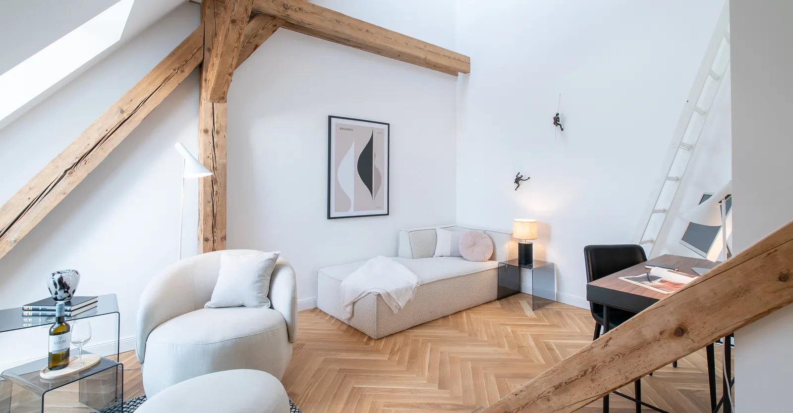Dachgeschoss mit Holzbalken, Sesseln und Arbeitsplatz nach dem Home Staging