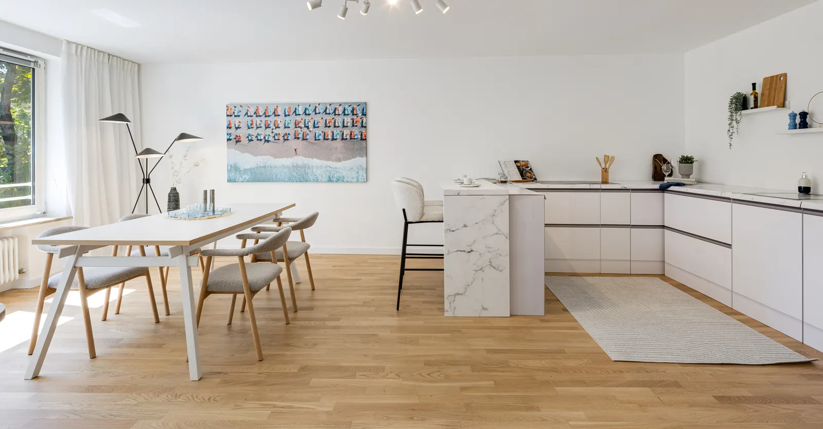 Wohnküche mit Esstisch, Stühlen und Wandbild nach dem Home Staging