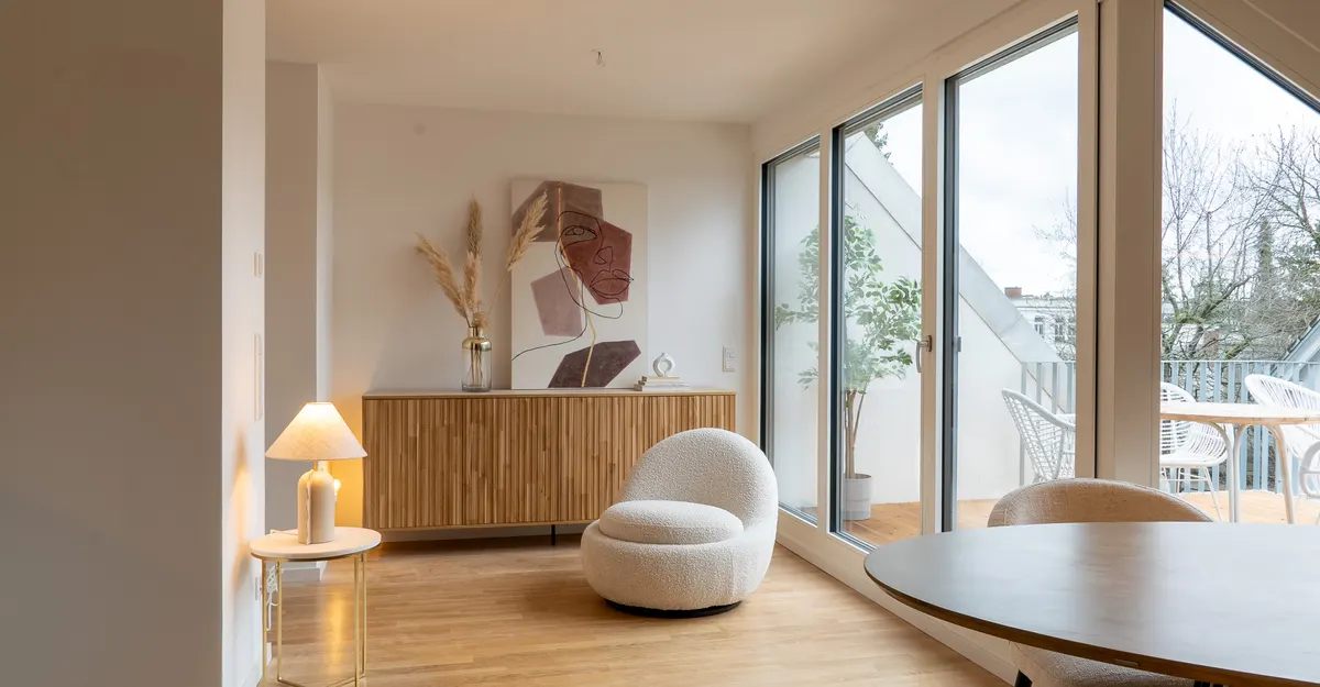Wohnbereich mit Dachterrassentür nach dem Home Staging mit Sideboard, Sessel, Leuchte und Esstisch