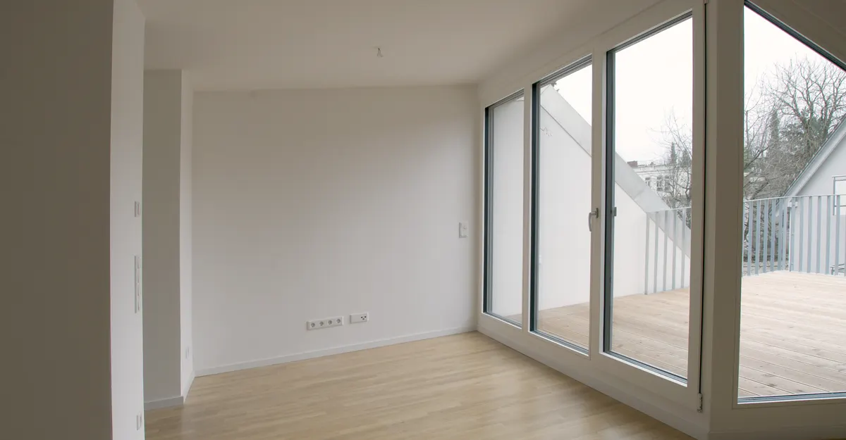 Leerer Wohnbereich mit Fensterfront zur Dachterrasse vor dem Home Staging