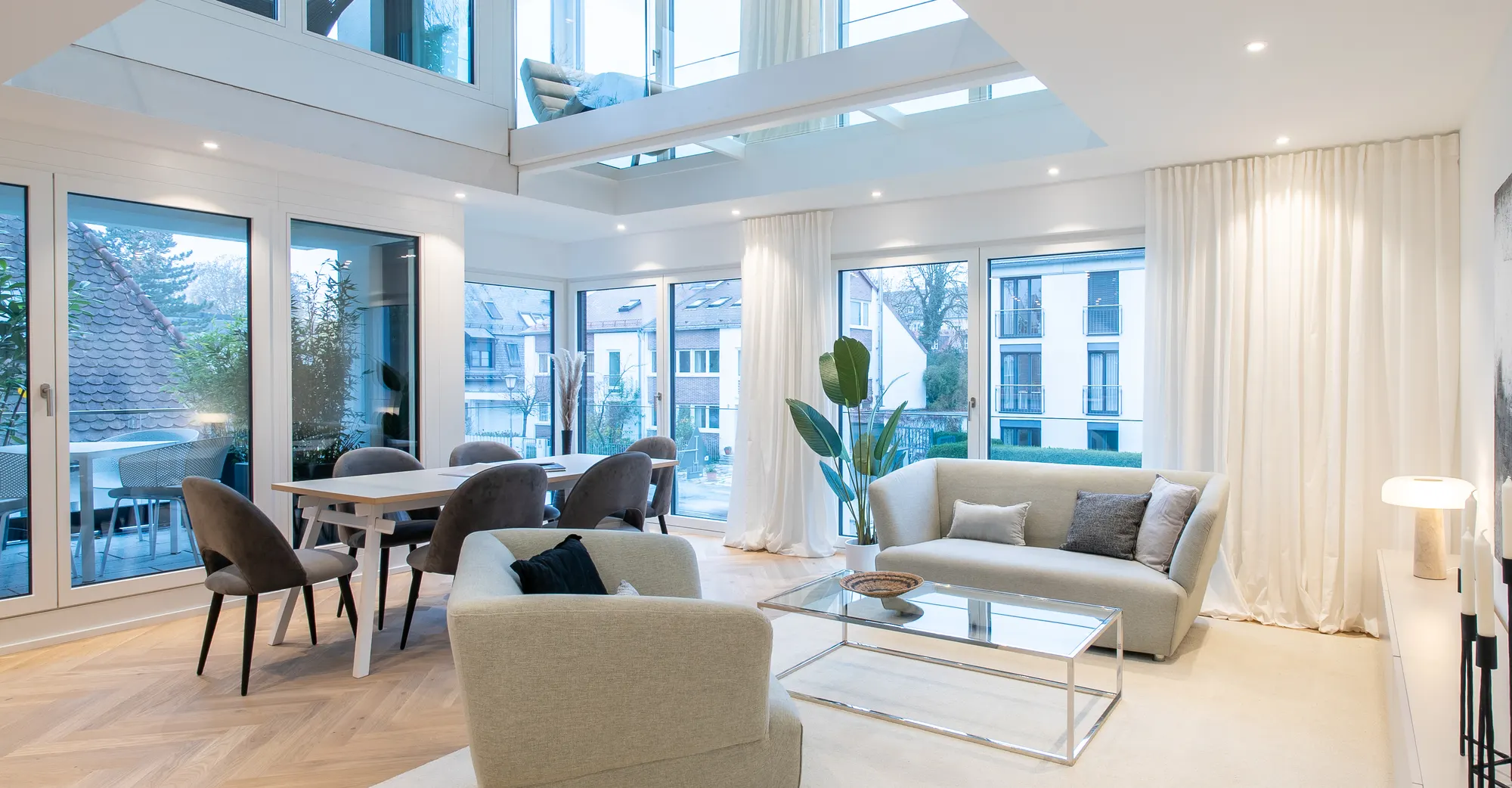 Wohnbereich mit Galerie in einer Neubauwohnung nach dem Home Staging, mit Sofa, Sessel, Essplatz und Teppich